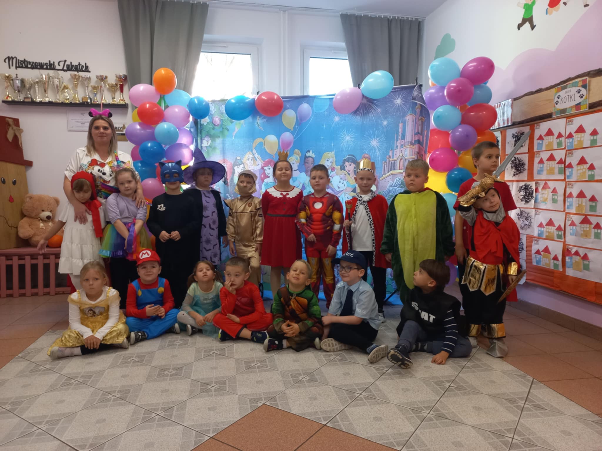 Dzieci z grupy Motylki stoją na tle bajkowej dekoracji