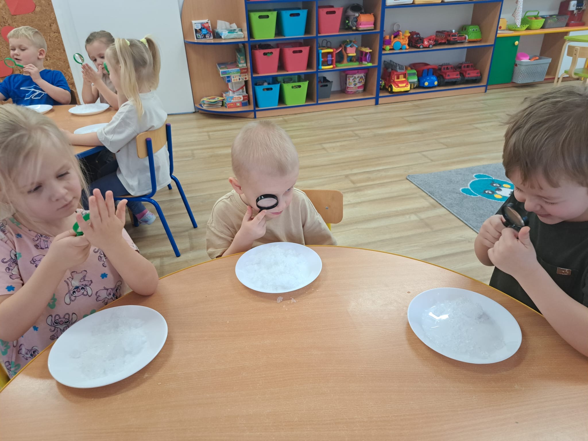 Dzieci przez lupę patrzą na śnieg