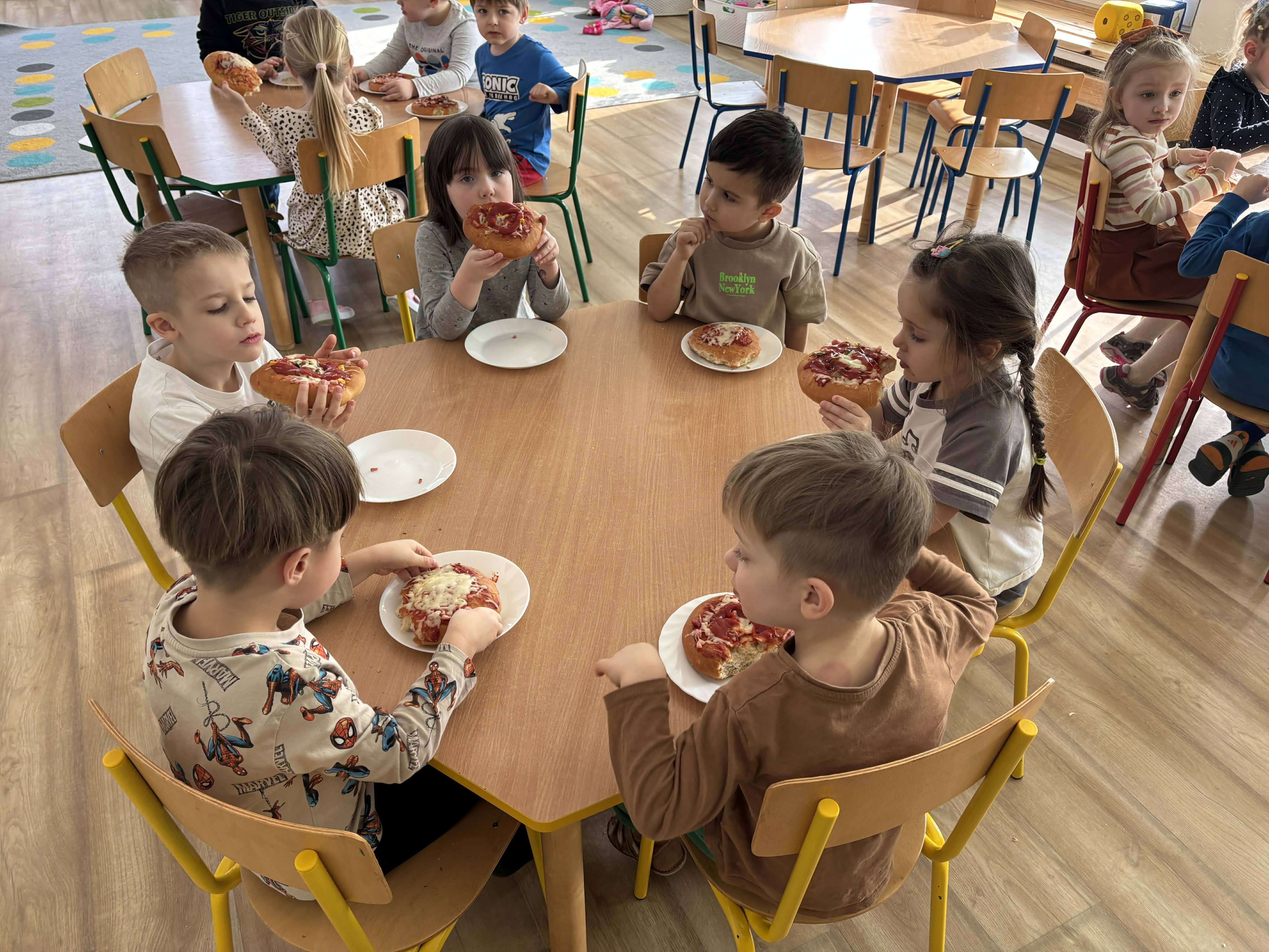 Dzieci jedzą pizzę