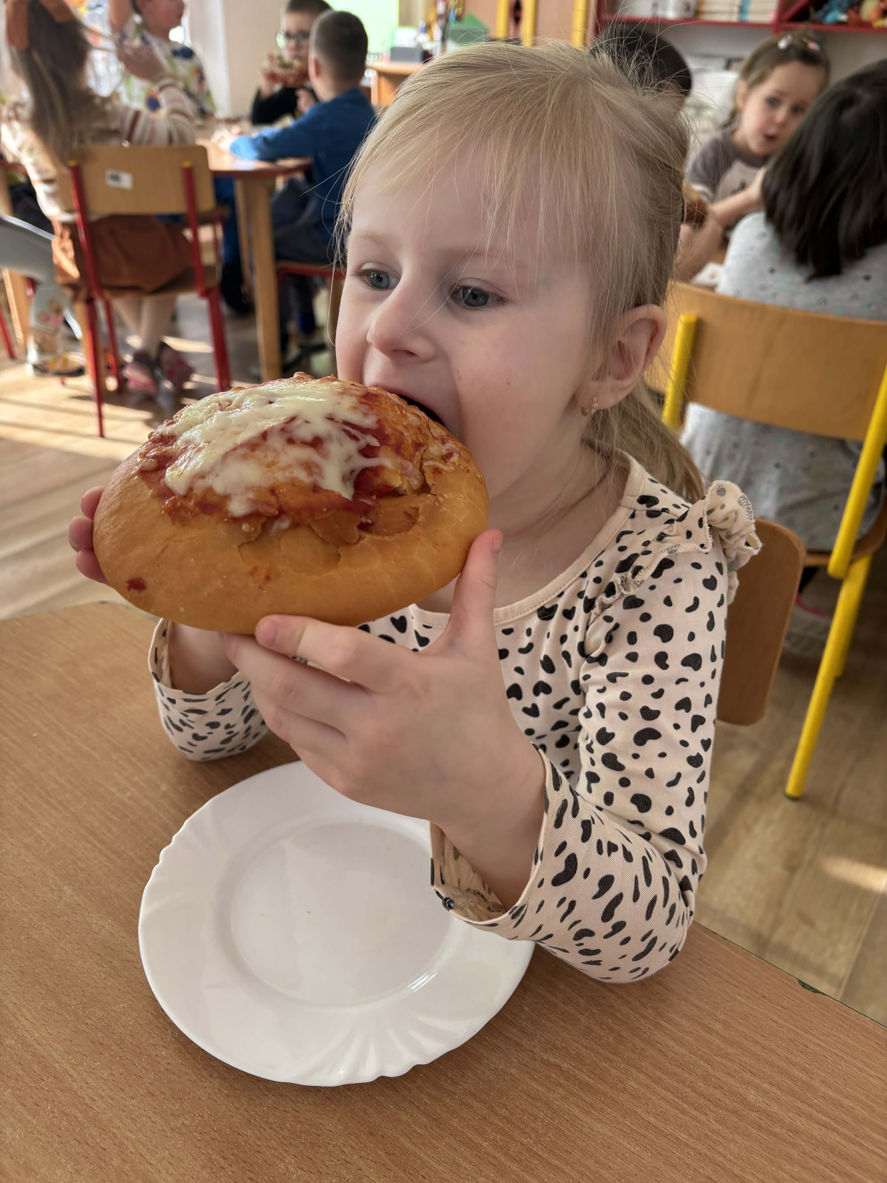 Dziewczynka je pizzę